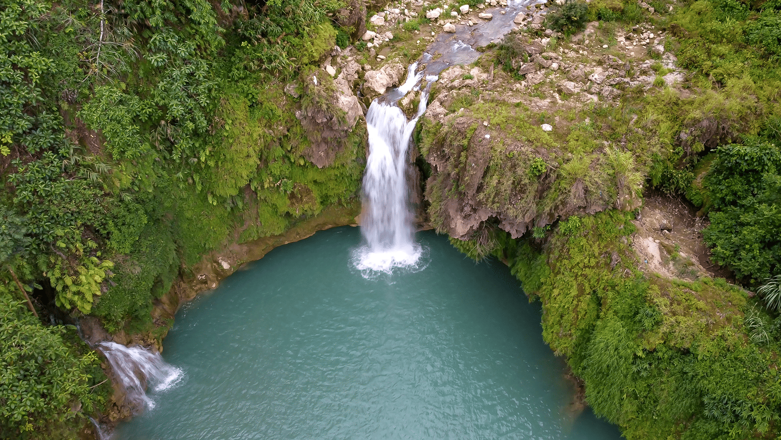 A waterfall flowing down a mid sized mountain.