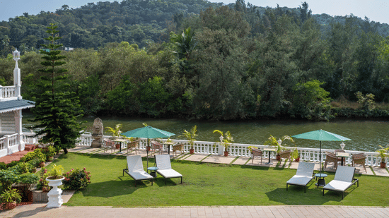 The outdoor premises of the hotel is exposed to lush green hills - Stone Wood Riverfront Resort, Siolim