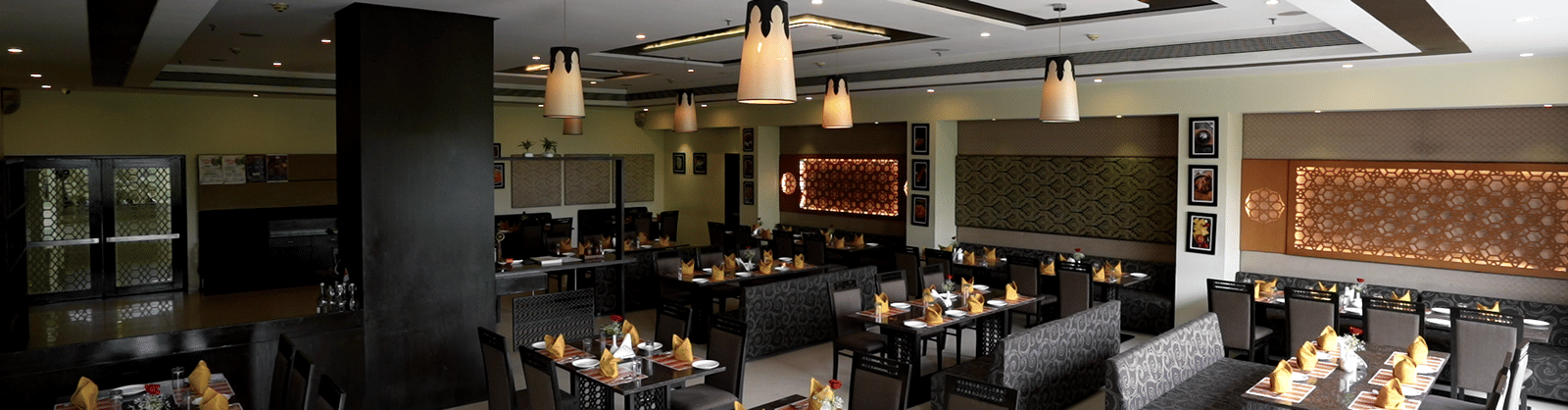 Elegant restaurant with neatly arranged tables and modern decor at Narayani Heights Hotel & Resorts, Ahmedabad.