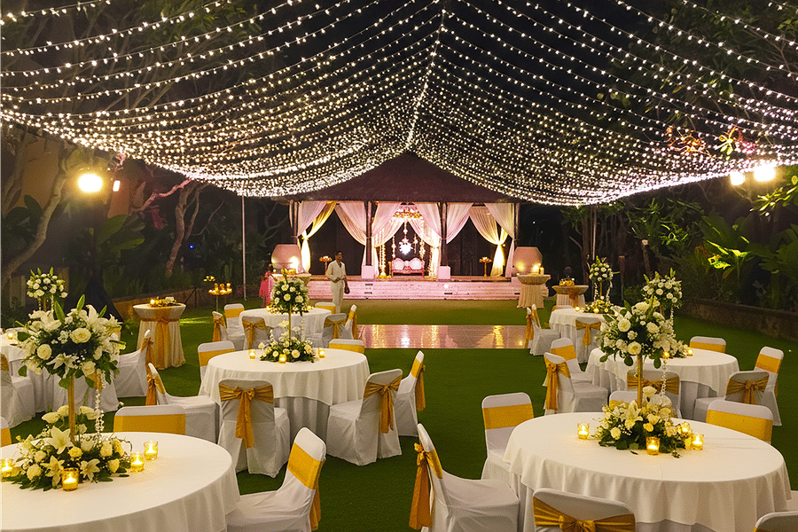Outdoor event at The Sonnet with round tables, white chairs, and a canopy of twinkling lights.