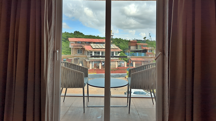 Room with glass balcony doors overlooking buildings and surrounding scenery