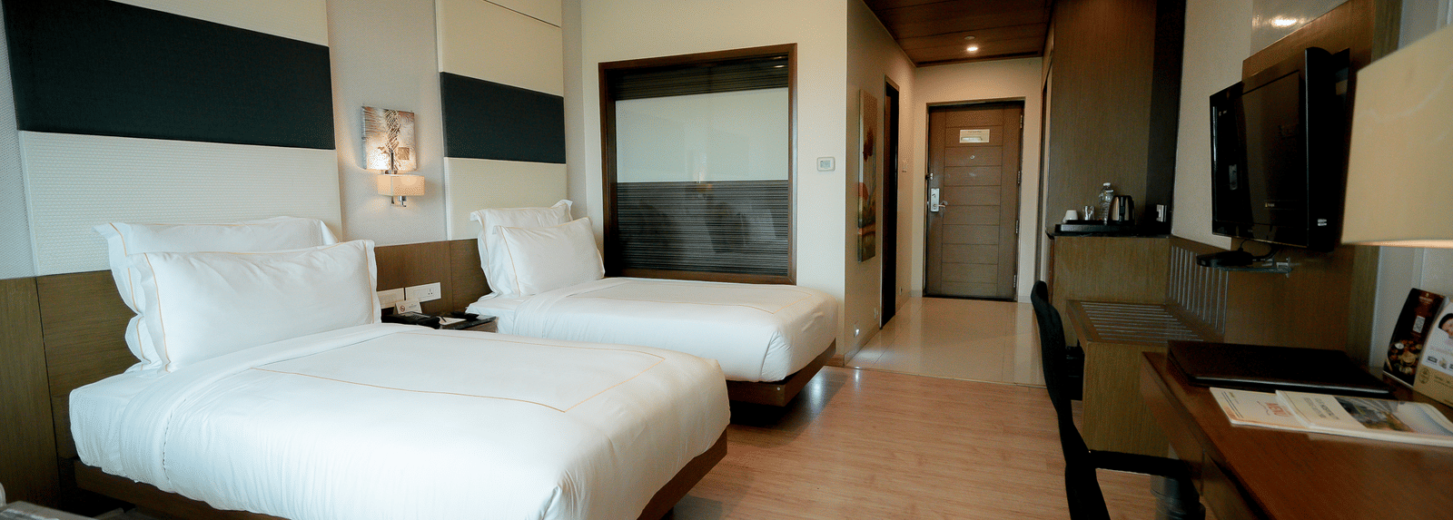 Executive room featuring a twin beds and a work desk at Narayani Heights Hotel & Resorts, Ahmedabad.