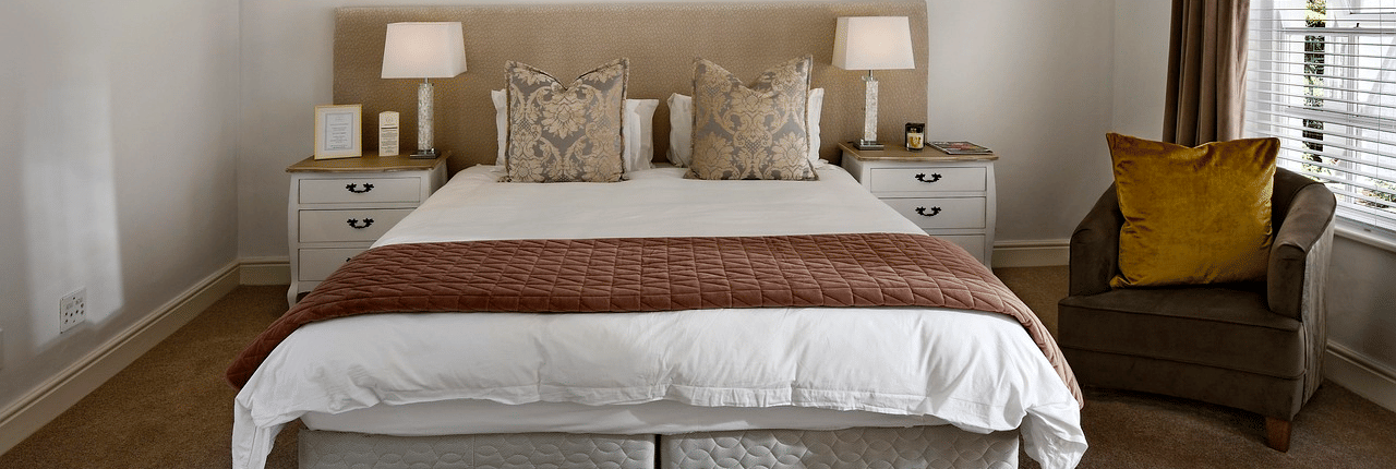 A double bed with a ceiling fan hanging over it in a bedroom.