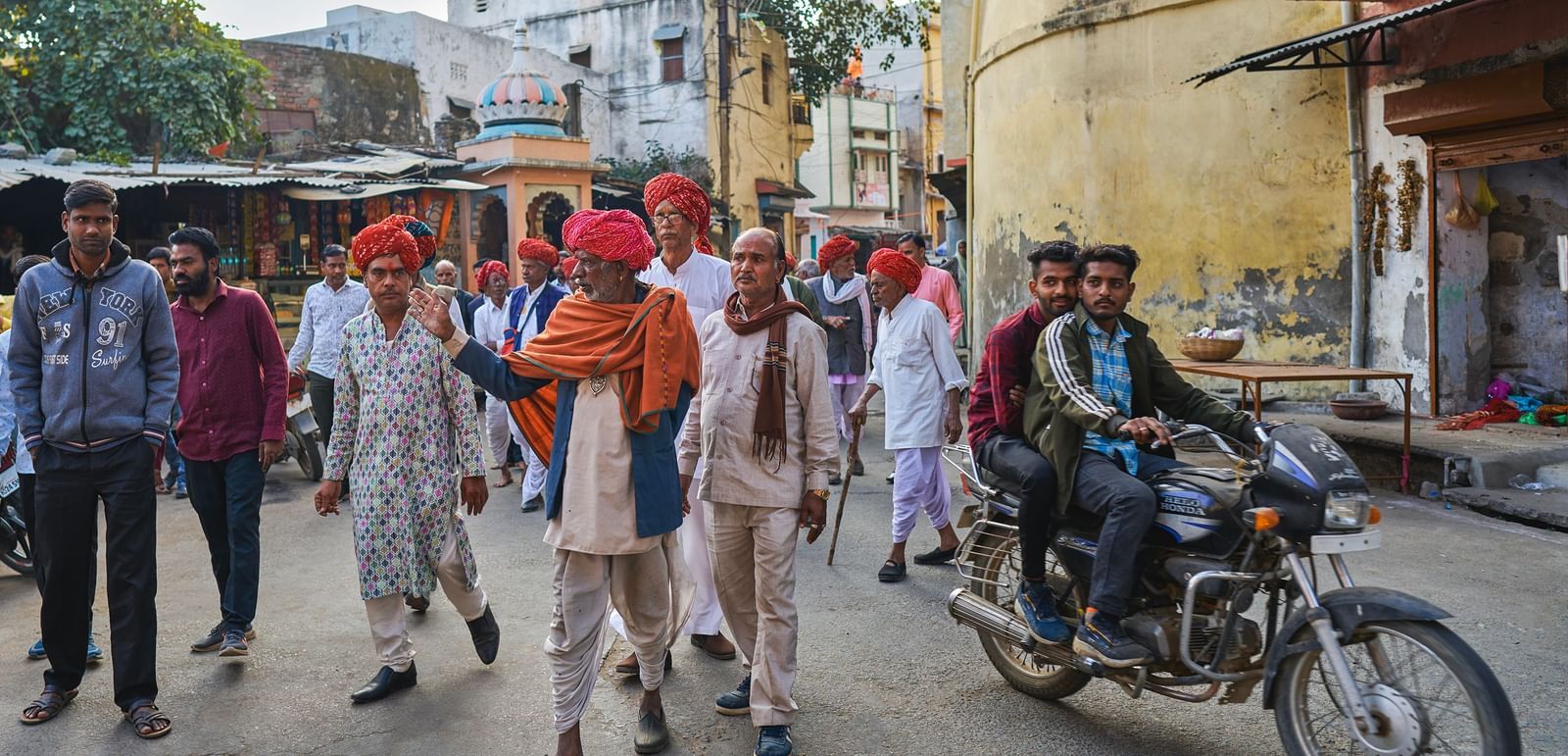 image of a group of local rajasthani men walking in the streets of the city wearing a pink traditional turban on their heads