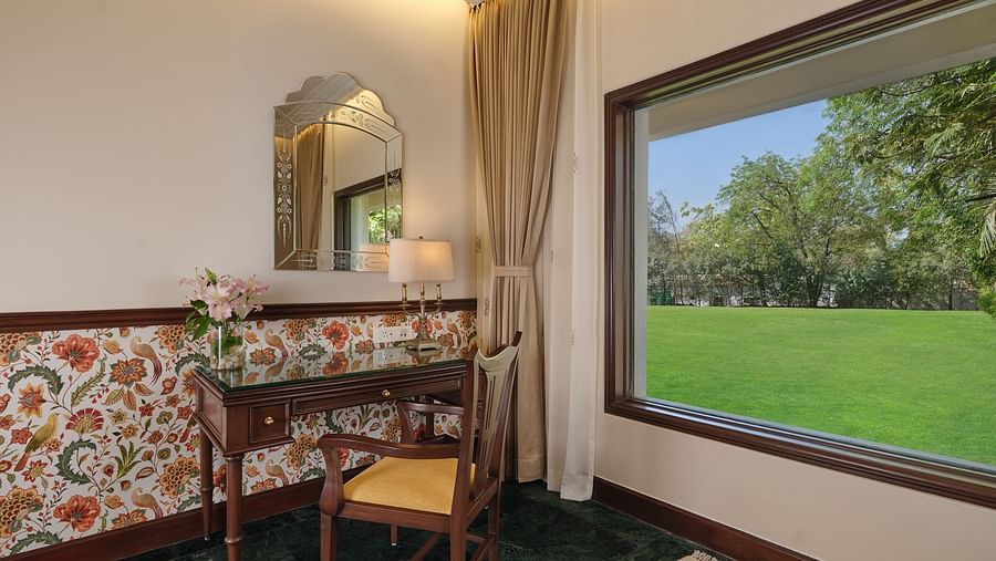 The Premium King Garden View Room at The Ummed Ahmedabad includes a well-placed work desk by the window, overlooking lush gardens