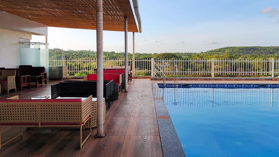 Side view of the swimming pool with seating area on the side at Vagator Downtown, Goa