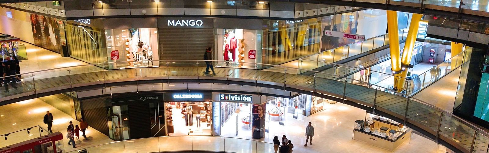An overview of a shopping mall with people and shops in view.