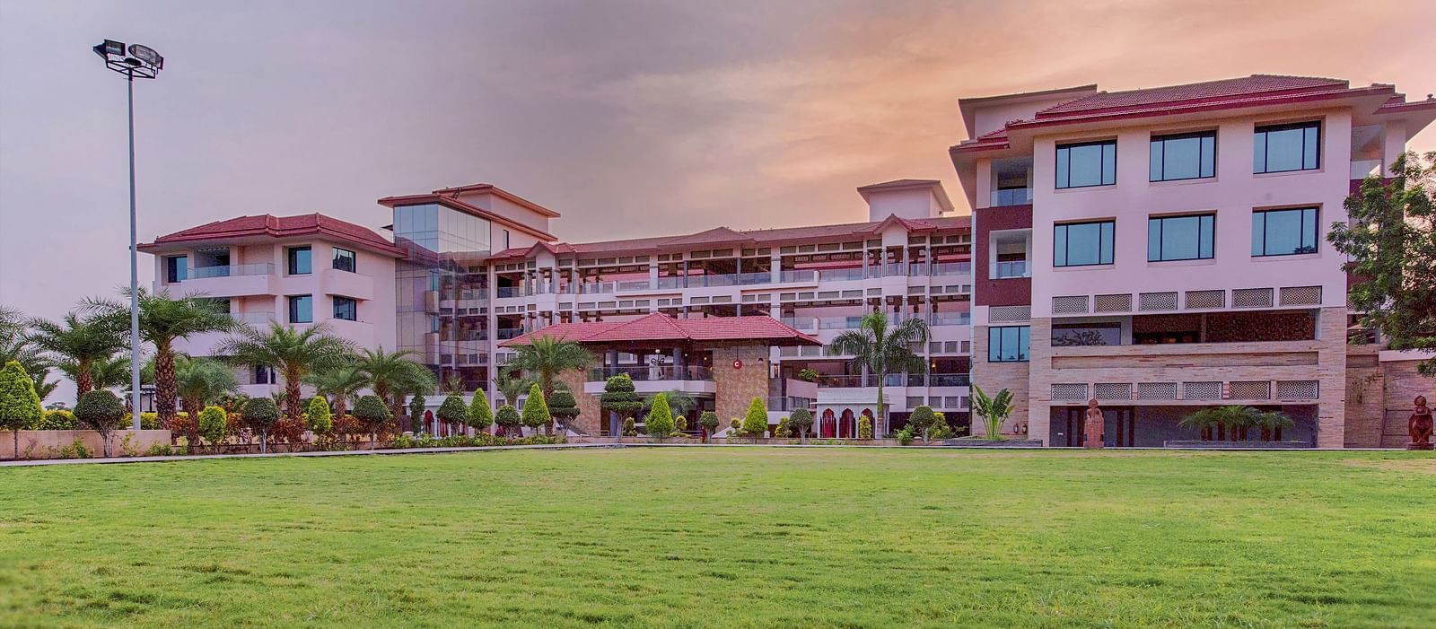 A huge lawn in front of a multi-storey building, captured after dusk - Crescent Spa & Resort, Indore