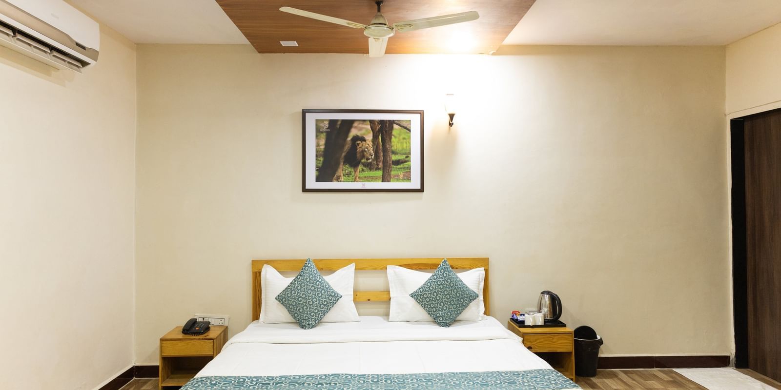 A neat room with a double bed, artwork, and warm lighting at Daksh Resort & Amusement Park.