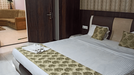 A bedroom at Ram Bhawan Ram Yamuna Prasad Hotel & Resort illuminated with soft warm lighting and minimalist furniture.
