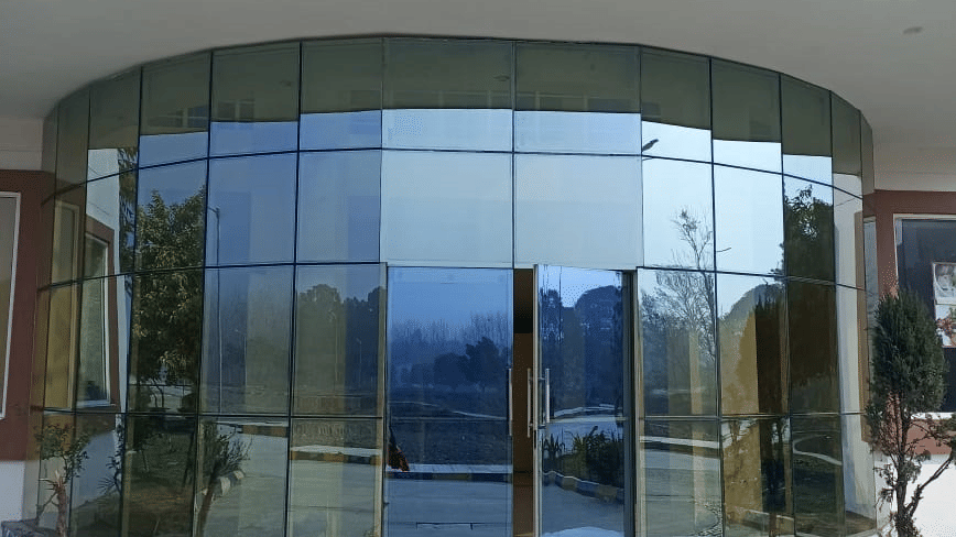 Main entrance of a building with curved glass doors at Livbox, Rudrapur.
