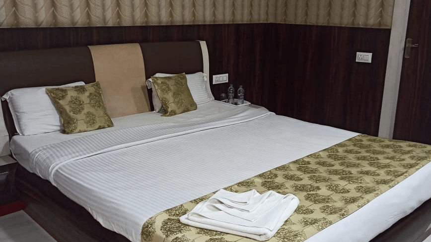 A spacious bedroom suite at Ram Bhawan Ram Yamuna Prasad Hotel & Resort including a dark wood coffee table and polished floors.