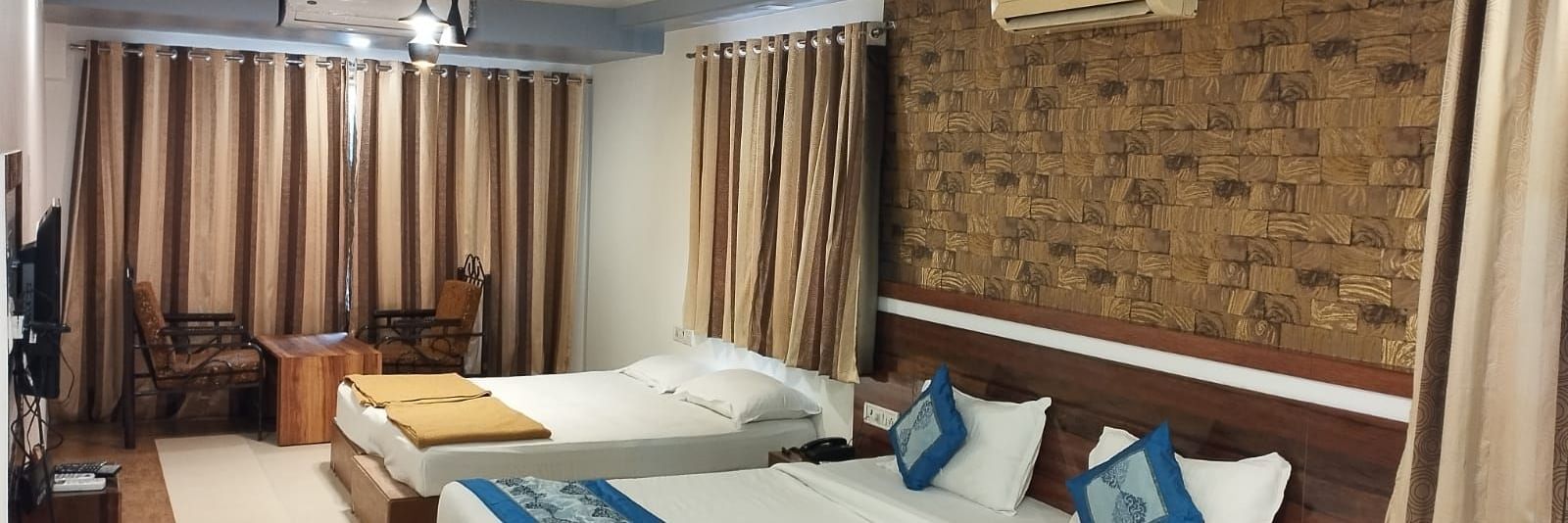 The Suite at Mountview Resort, furnished with two king size beds, drawn curtains, air-conditioning, and a seating area.