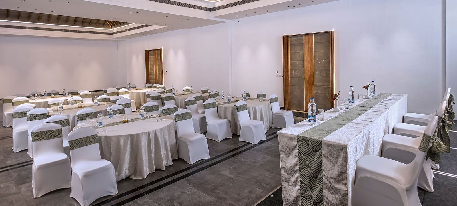 Another angle of the banquet hall with round tables and chairs | Great Trails Wayanad by  GRT hotels.