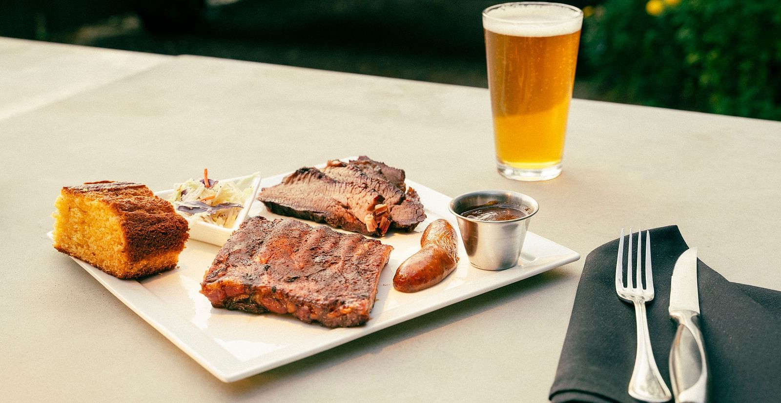 A steak served alongside a glass of beer - The Groveland Hotel.