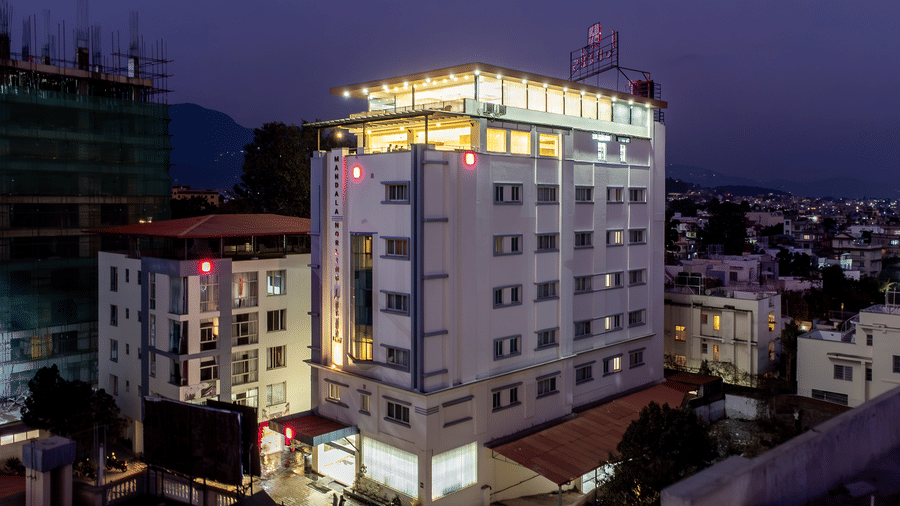 Night view of the exterior of Mandala Norling Lords Prime hotel in Kathmandu which has illuminated logo, extended portico and spacious driveway.