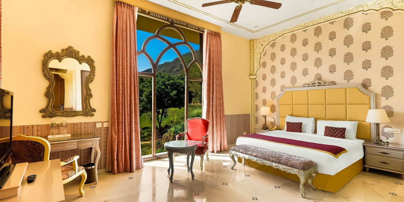 Elegant double bedroom at Rajasthali Resort Jaipur with plush interiors, arched windows, and royal decor touches.