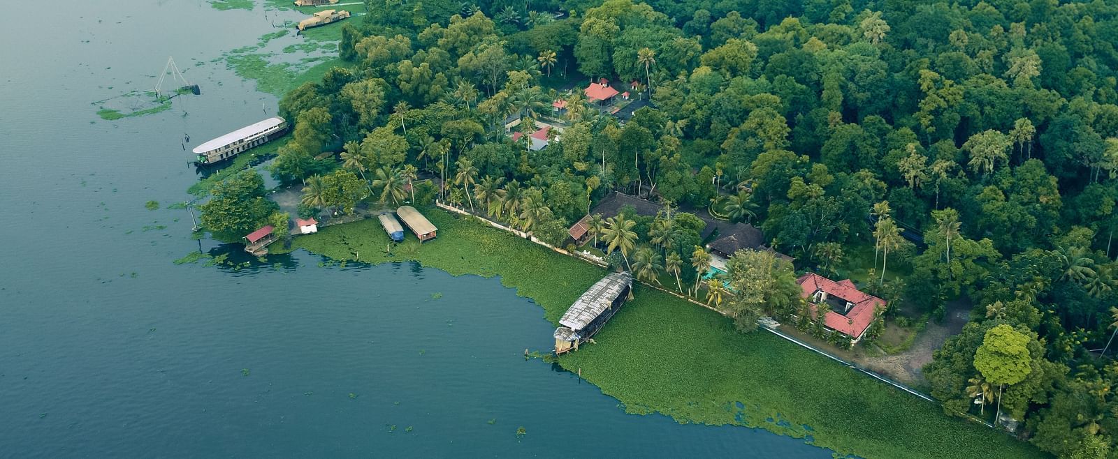 An aerial shot showcasing the Vembanad Lake and the resort surrounded by lush greenery - BluSalzz Villas - Muhamma Resort, Alleppey