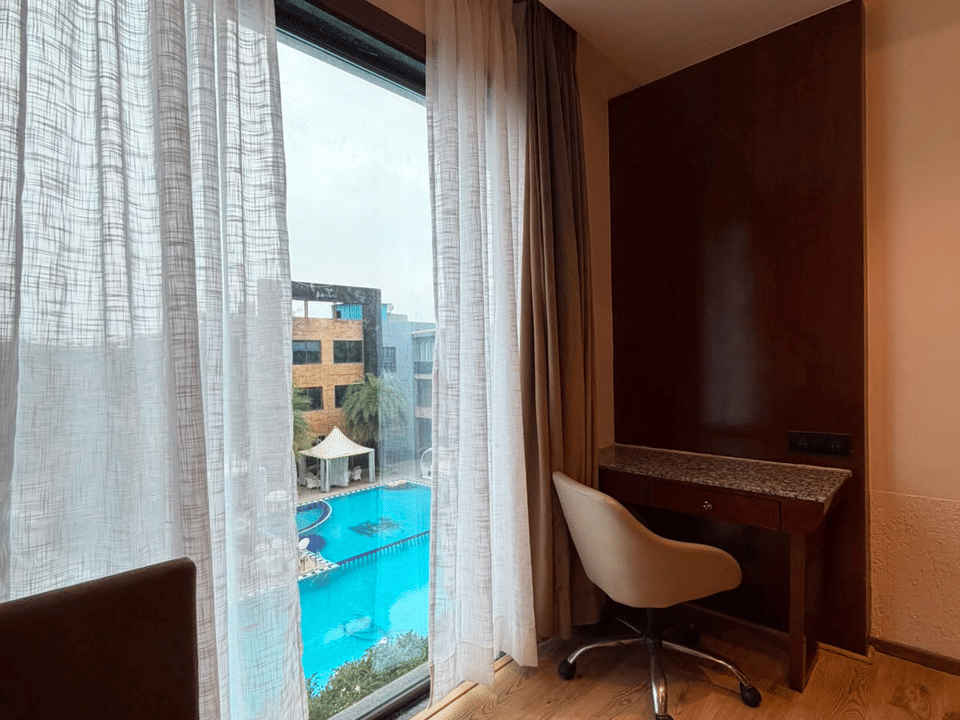 Deluxe Pool Room, Writing desk and window with pool view