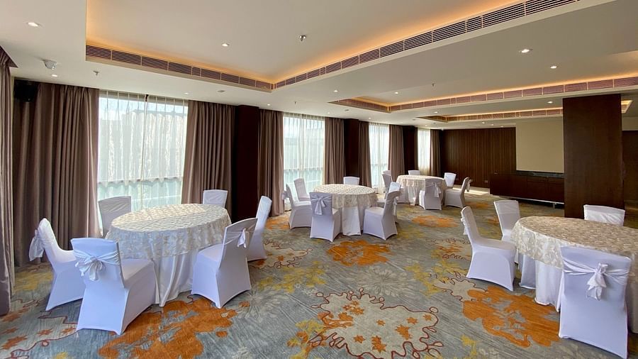 An image of a banquet hall with its seating arrangement and subtle decoration with lighting - Hideaway banquets & Lawns, Greater Noida