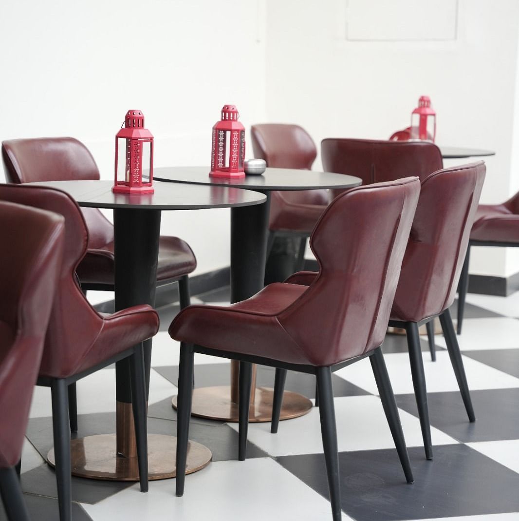 Contemporary café seating with maroon chairs and checkered flooring