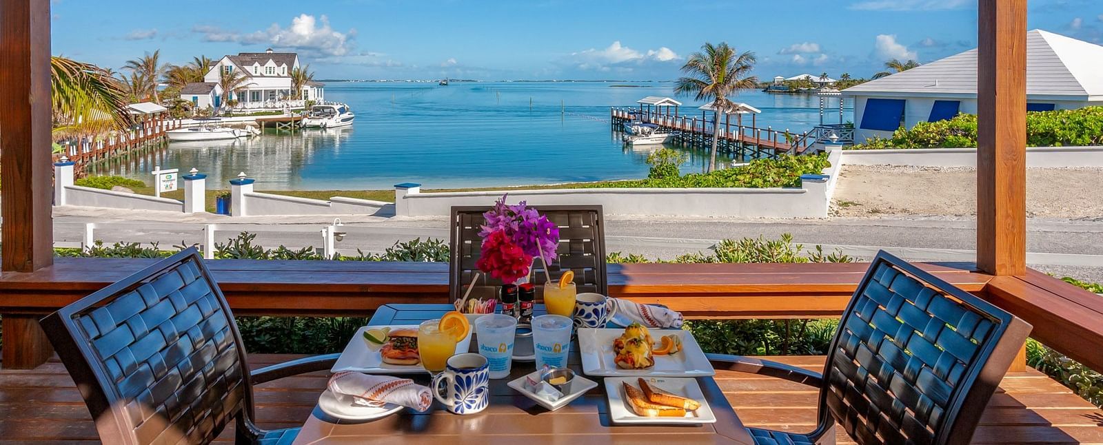 Dining setup on a patio overlooking boats and water | Abaco Inn