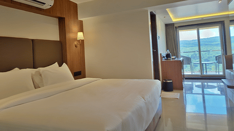 Bedroom with a double bed, air conditioner, wooden furnishings, and balcony access