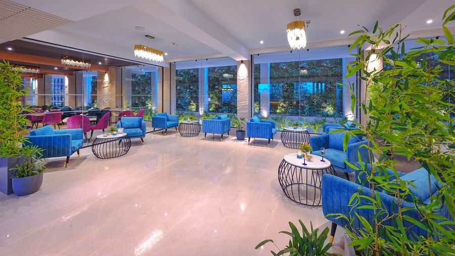 A bar featuring blue and red sofa chairs - Royale Sarovar Portico, Agra