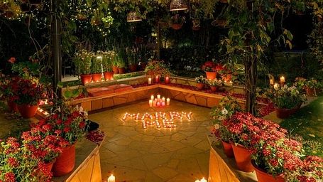 Night view of garden pathway with stairs lit by candles and surrounded by plants at Karma Chalets.