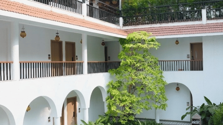A villa courtyard showing outdoor seating, balconies, and a chevron floor at Bougainvillea, Alibaug.