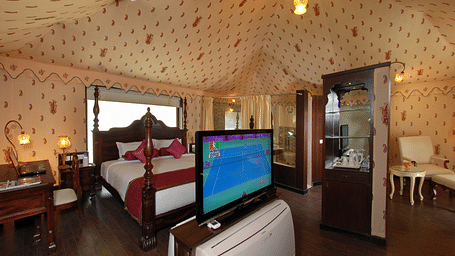 Image of room with a bed and a television in front of the bed at Rajasthali Resort & Spa Jaipur.