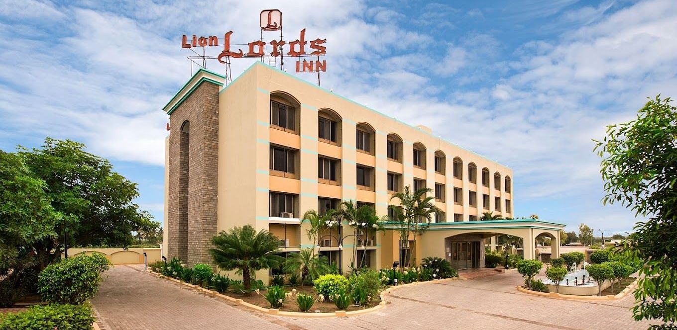The front of a light-coloured building visible on a sunny day - Lion Lords Inn Rajula