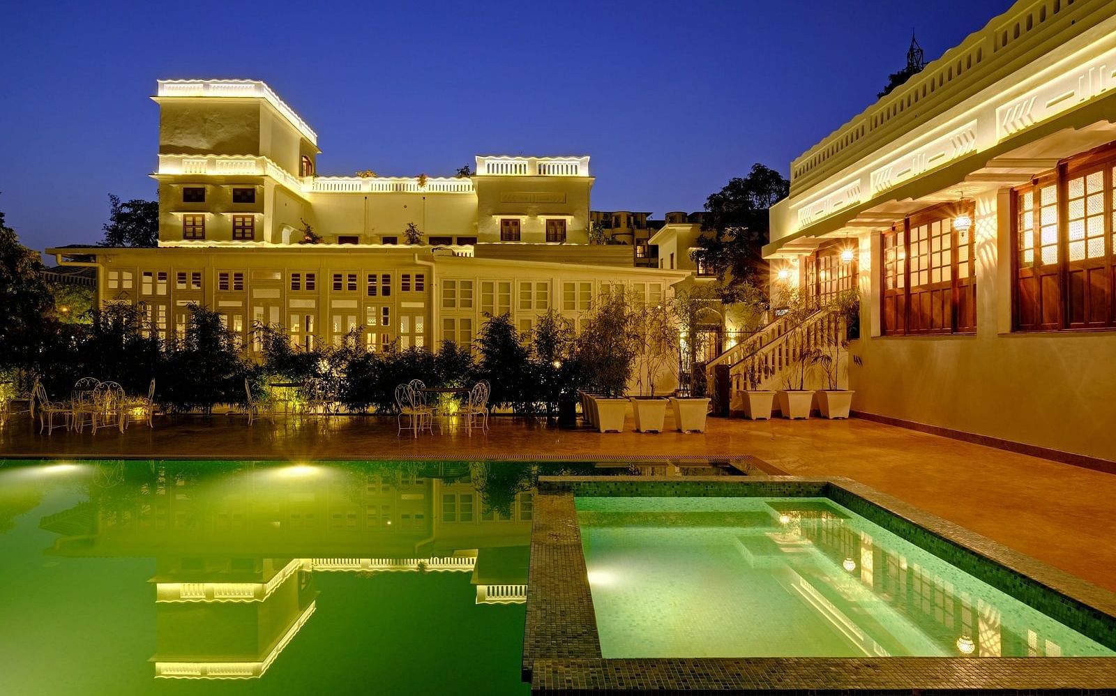 Swimming pool area of Saraca Hotel, Lucknow with the hotel building the backdrop during blue hour