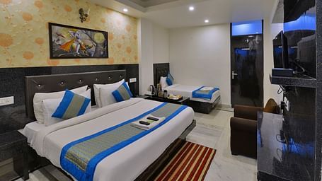 room with double bed, accent wall art, and modern amenities at Hotel Noida International.