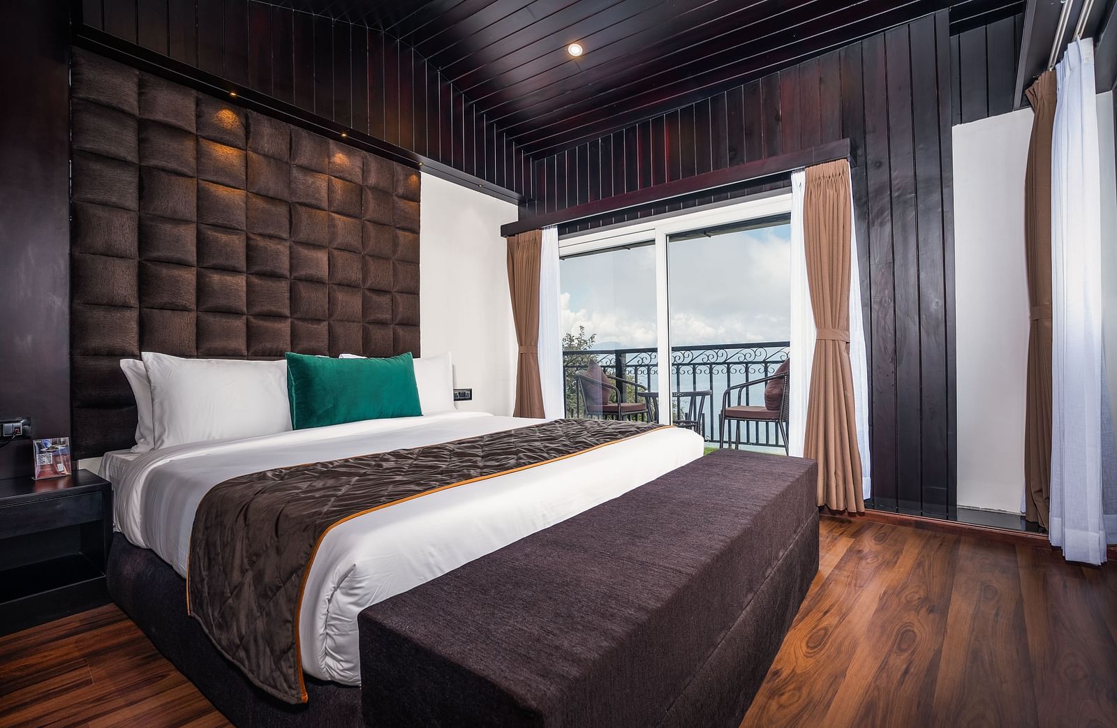 Image of a room that is well furnished with a king size bed and also has an access to a private balcony