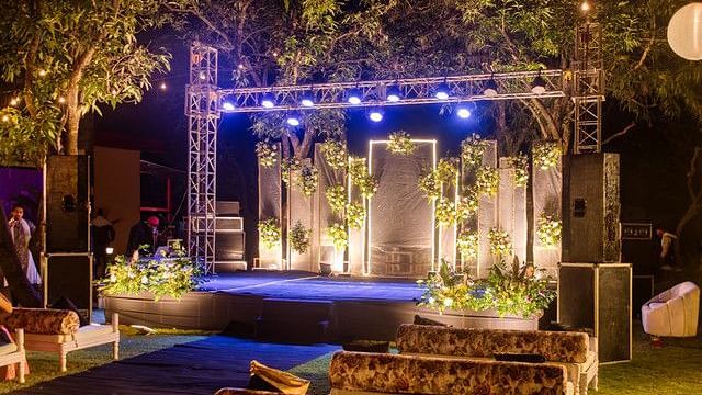 alt-text Illuminated stage with lighting and floral arrangements.
