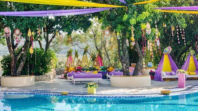 alt-text Festive poolside wedding venue with colorful decorations.