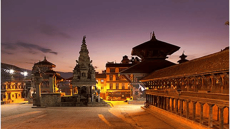 An overview of Bhaktapur Durbar Square in the night with the lights on during the twilight sky