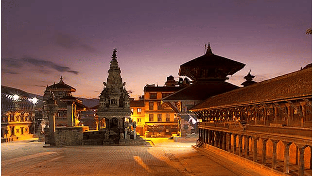 An overview of Bhaktapur Durbar Square in the night with the lights on during the twilight sky