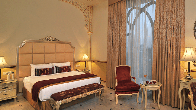 Image of a room with a bed and a chair on the side at Rajasthali Resort & Spa Jaipur.