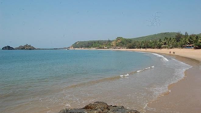 An overview of a beach's coastline with trees covering on the mountain - Gamyam Retreat