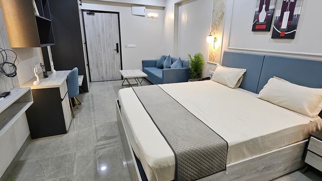 A spacious room with a large bed, side photo frames, and a wall-mounted TV at Urban Suites by BluSalzz, Jaipur.