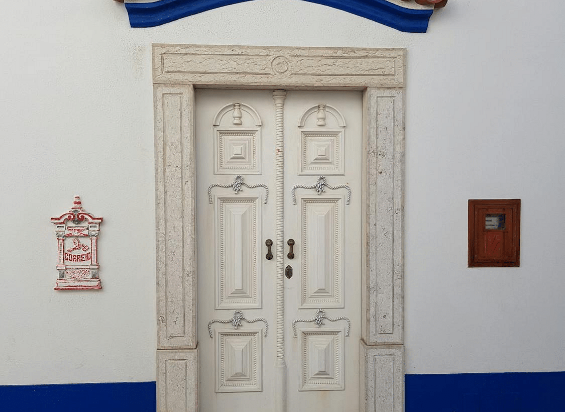 A classic white door with a blue-tiled frame, showcasing traditional architectural elements.