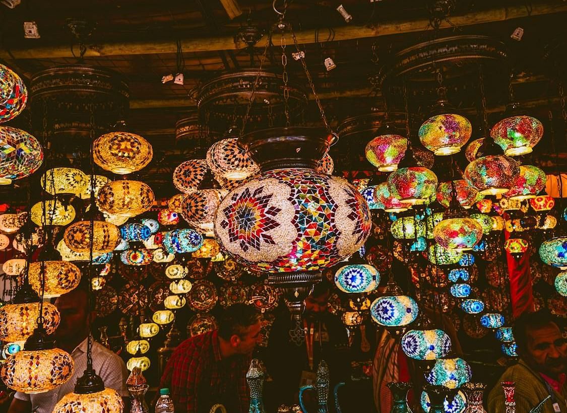 A low-angle shot of a market stall with hanging lanterns, illuminated by overhead lights - Rhino and River BluSalzz Collection, Pobitora