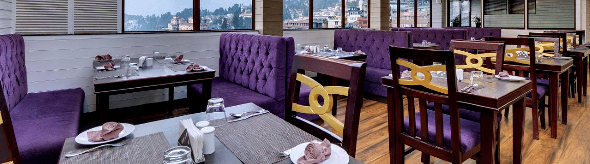An image of a restaurant with seating arrangement and minimal decoration - Sumitel Darjeeling