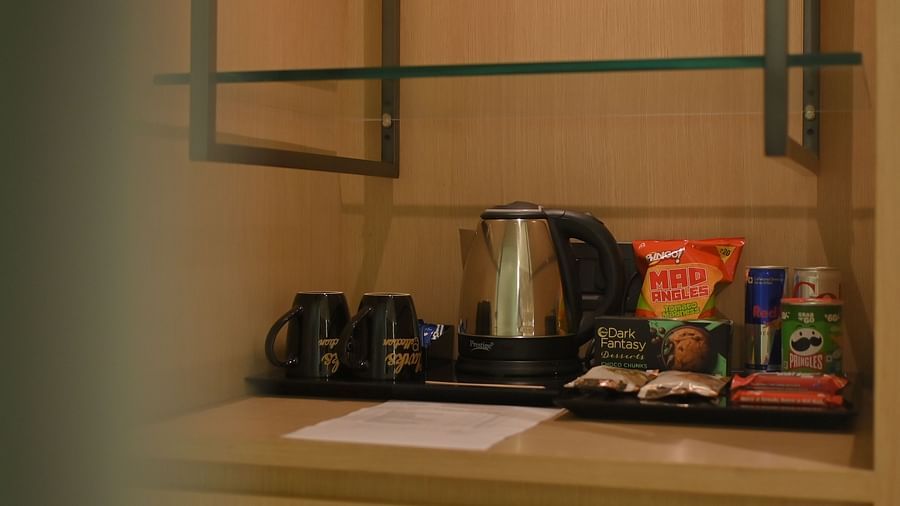 Tea and coffee maker with multiple sachets and snacks displayed on a table at Clarks Collection Grand Sapphire, Ajmer.