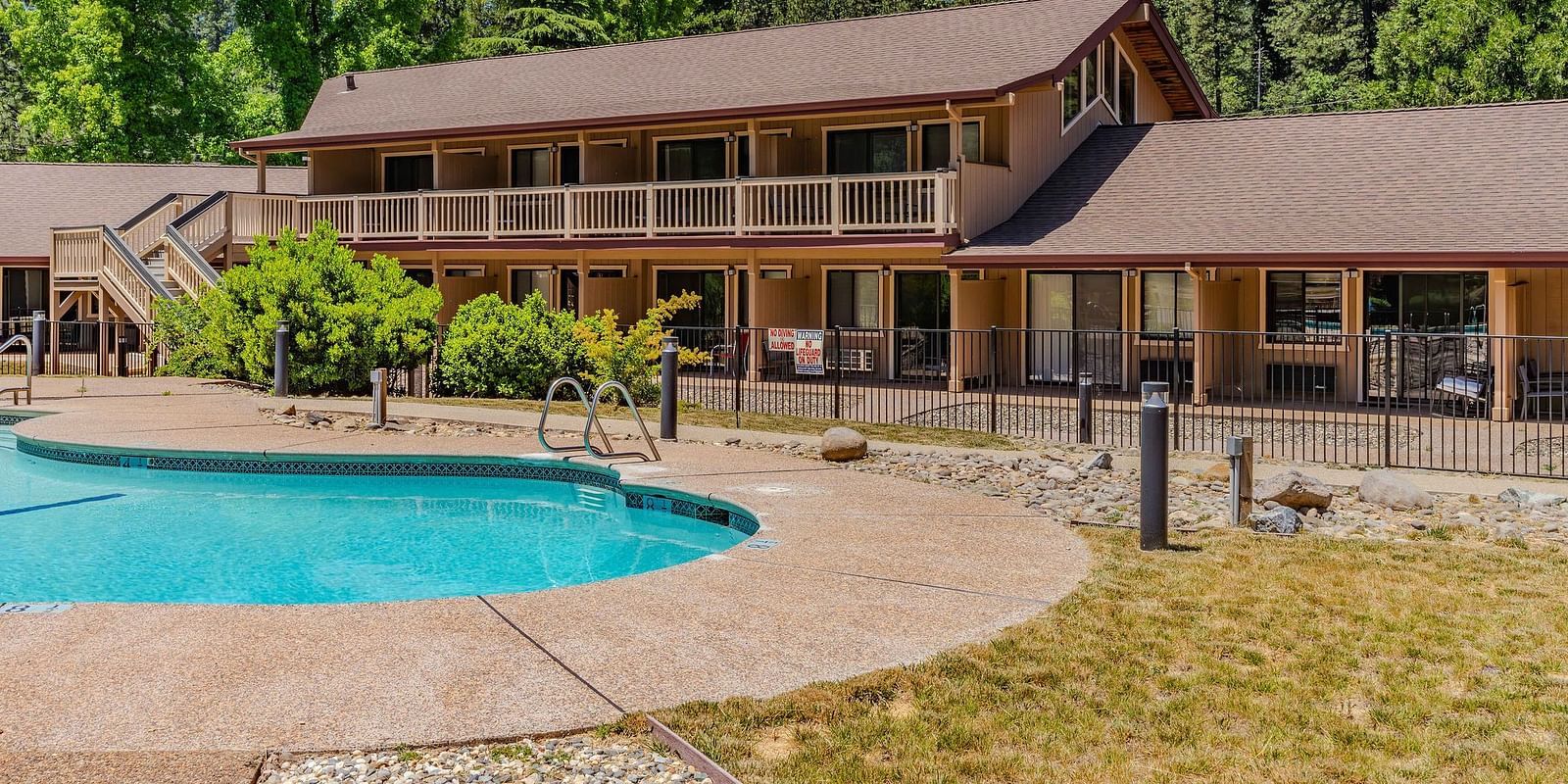 A view of an outdoor swimming pool with a cabin in the backdrop