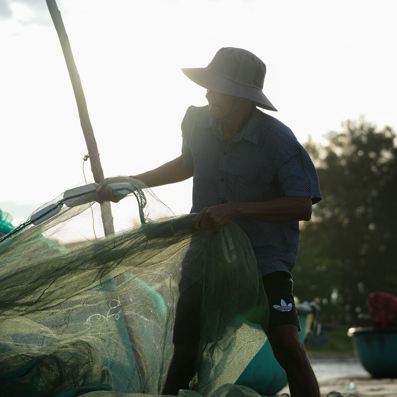 A fisherman reeling in his catch on the beach
