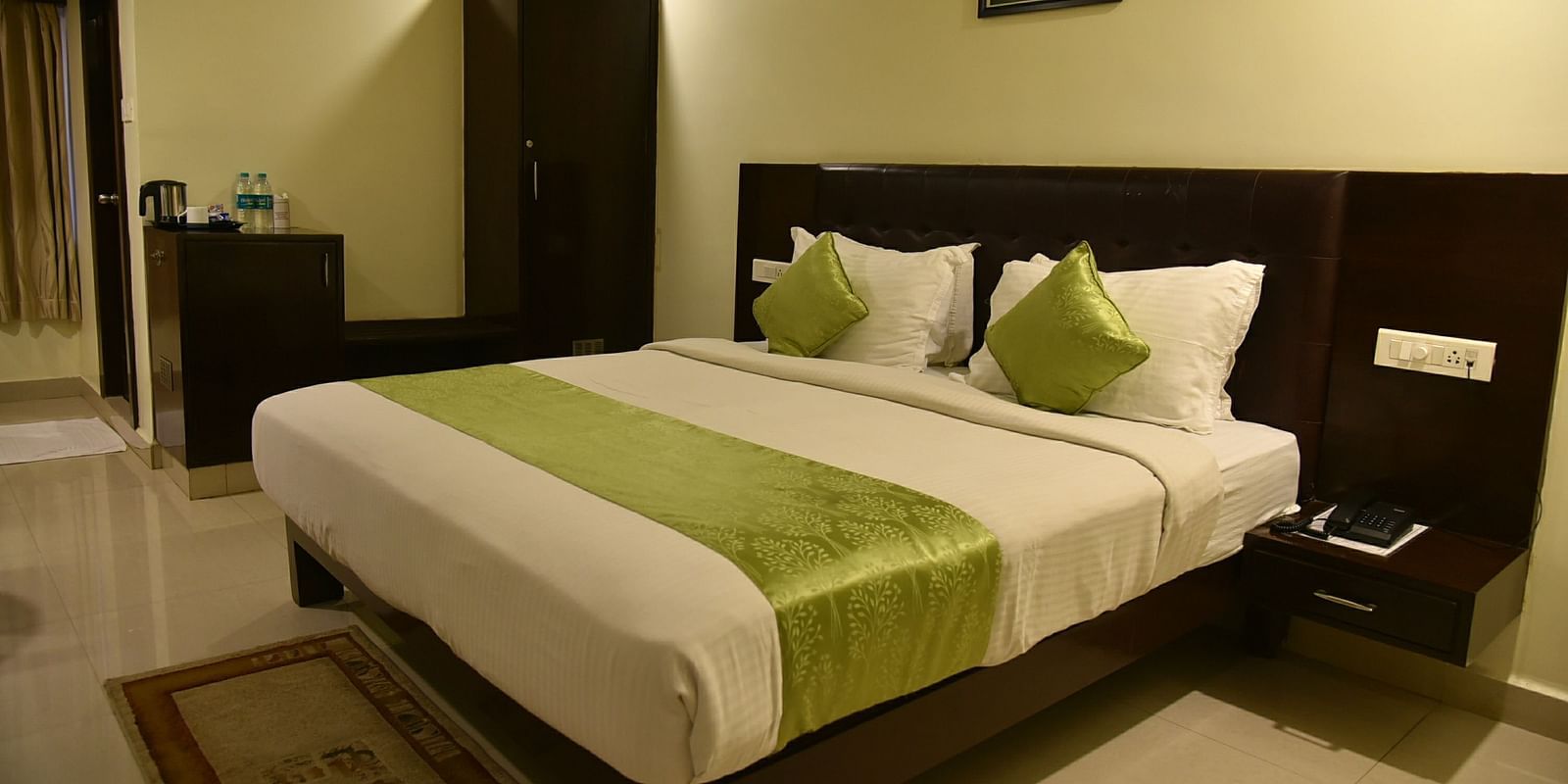 Room with bed, wardrobe and side table at Hotel Green Apple