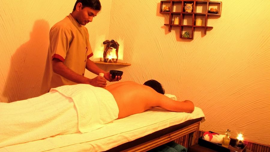 a masseur applying essential oils on a customer for spa